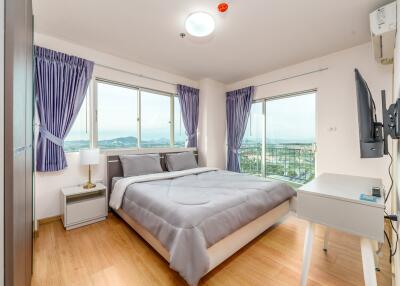 Bright bedroom with large windows and a double bed