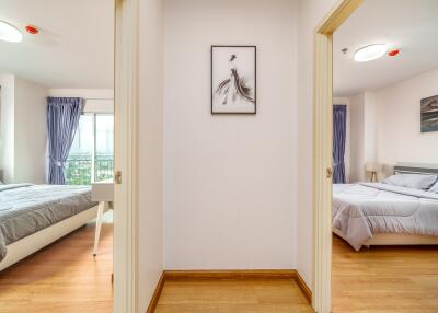 Two bedrooms with wooden floors and modern furnishings viewed from a hallway