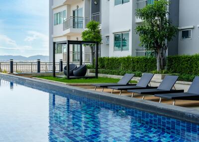 Outdoor pool area with lounge chairs and greenery