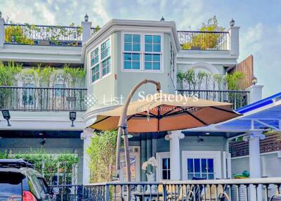 Front view of a two-story building with a balcony and a lower-level covered patio