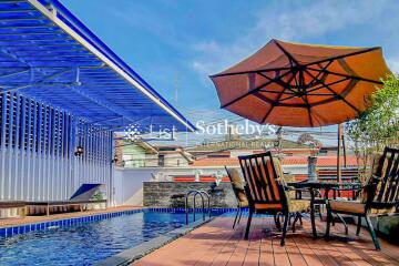 Patio with poolside seating and umbrella