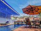 Patio with poolside seating and umbrella