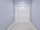 Hallway with double white doors and tiled floor