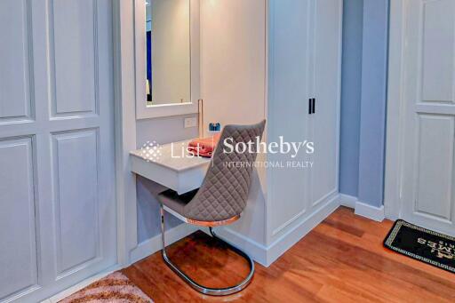 Cozy bedroom with a vanity desk and chair, surrounded by ample closet space