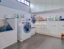 Laundry room with washing machine, dryer, sink, and storage cabinets