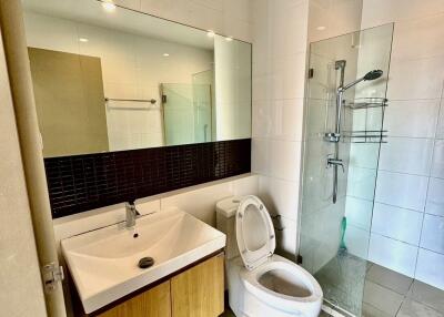 Modern bathroom with glass door shower, toilet, and sink