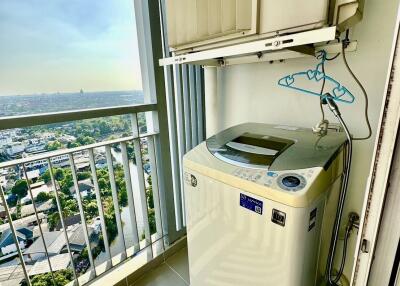 A compact laundry area with a washing machine and a scenic view from the balcony.