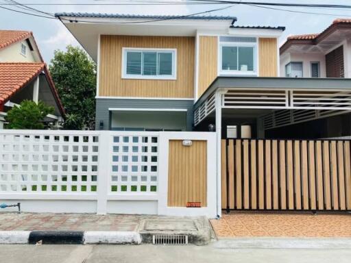 Front exterior view of a modern two-story house with a fenced yard