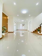 Spacious living room with modern lighting and stairway