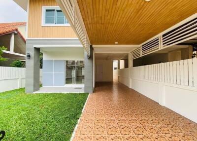 Front view of a modern house with a covered driveway and green lawn