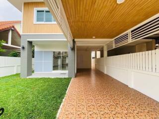 Front view of a modern house with a covered driveway and green lawn