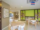 Modern living area with tables and chairs, vibrant green wall, and bookshelves