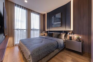 Modern and cozy bedroom with a large bed, stylish decor, and large windows allowing ample natural light