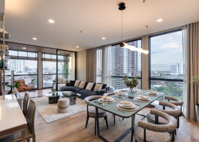 Spacious living room with large windows, city view, and modern furnishings