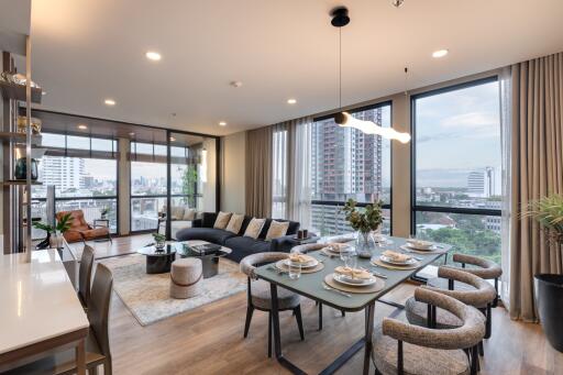 Spacious living room with large windows, city view, and modern furnishings