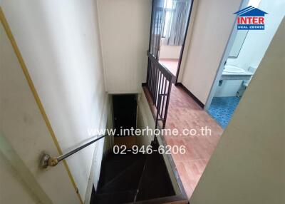 Staircase leading to lower level with view of adjacent bathroom and living space