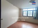 Dimly lit bedroom with window and wood flooring