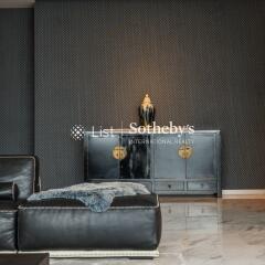 Modern living room with black leather furniture and decorative cabinet