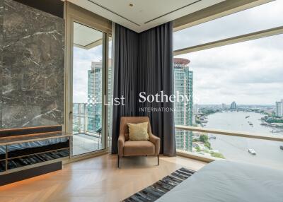 Bedroom with large window overlooking a cityscape and river