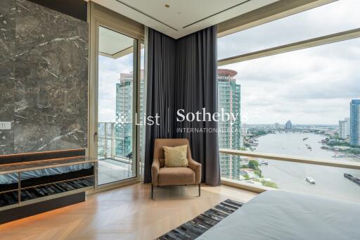 Bedroom with large window overlooking a cityscape and river