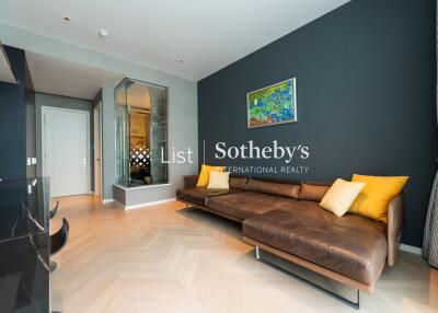 Modern living room with a brown leather sectional sofa, wooden flooring, and a large mirror on the wall