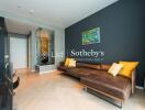 Modern living room with a brown leather sectional sofa, wooden flooring, and a large mirror on the wall