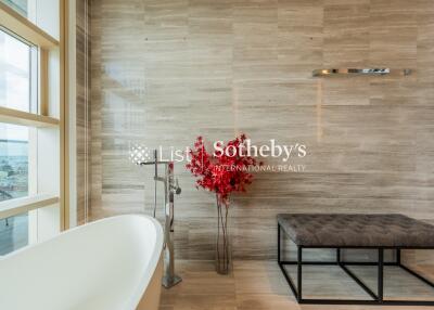 Modern bathroom with freestanding bathtub and red plant