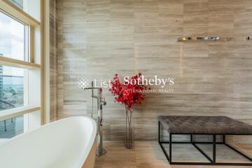 Modern bathroom with freestanding bathtub and red plant