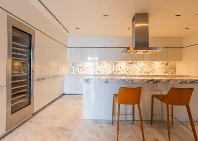 Modern kitchen with marble countertops and orange bar stools