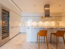 Modern kitchen with marble countertops and orange bar stools