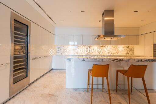 Modern kitchen with marble countertops and orange bar stools