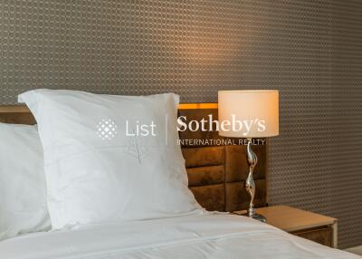 Bedroom with bedside lamp and patterned wallpaper