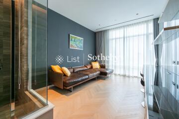 Modern living room with a large window, hardwood floor, and a comfortable brown leather sofa