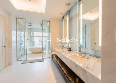 Modern bathroom with double sinks, large mirrors, a bathtub, and a shower