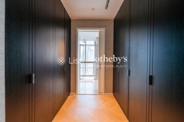 Modern hallway with dark wooden cabinets and a bright doorway