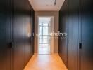 Modern hallway with dark wooden cabinets and a bright doorway