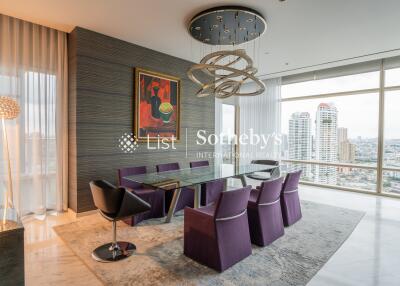 Modern dining area with a large glass table, stylish chairs, and city view