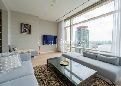 Modern living room with large windows offering a city and river view