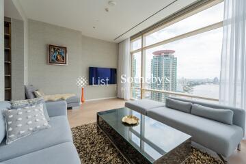 Modern living room with large windows offering a city and river view