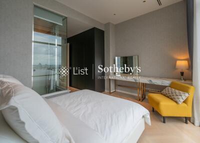 Modern bedroom with a large bed, a yellow chair, and a vanity table