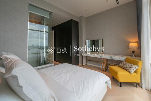 Modern bedroom with a large bed, a yellow chair, and a vanity table