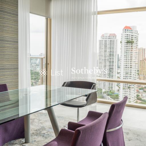 Modern dining area with glass table and city view