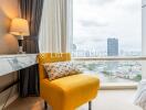 Living room with a yellow armchair and a city view