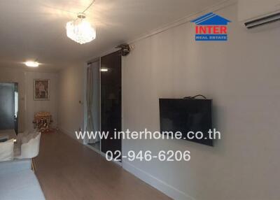 Main living room with wall-mounted TV and chandelier