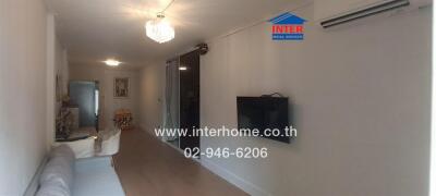 Main living room with wall-mounted TV and chandelier