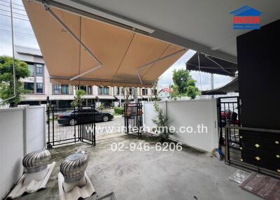 Outdoor patio or driveway area with awning and gate