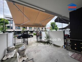 Outdoor patio or driveway area with awning and gate