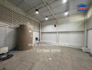 spacious indoor utility or storage room with protective roofing and a large water tank