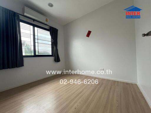 Unfurnished bedroom with wooden flooring and window with curtains