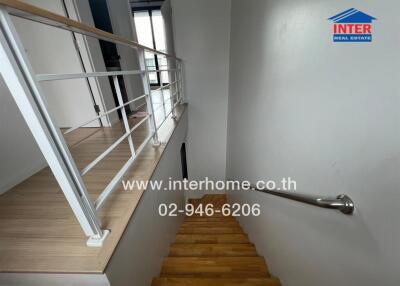 Staircase inside the building with wooden steps and white walls